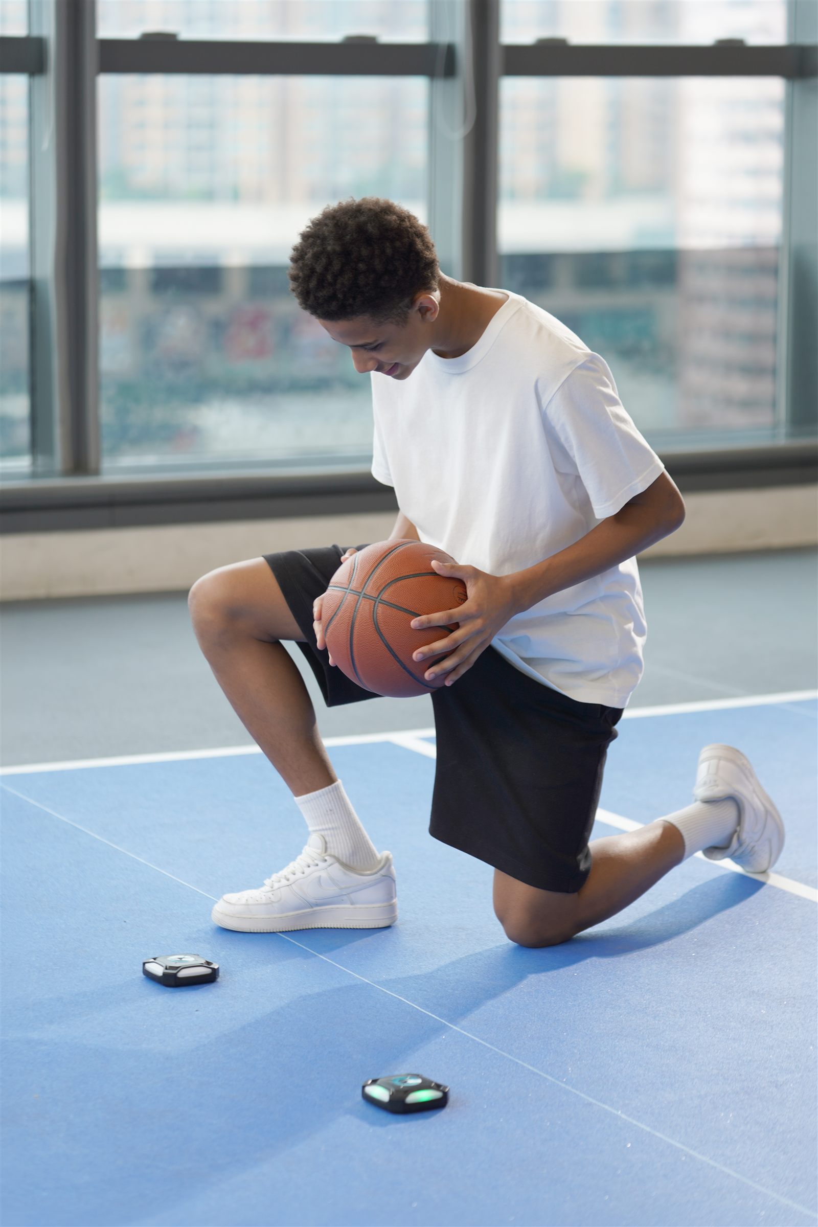 Young athlete training agility and reaction speed with a light-up pod on the court